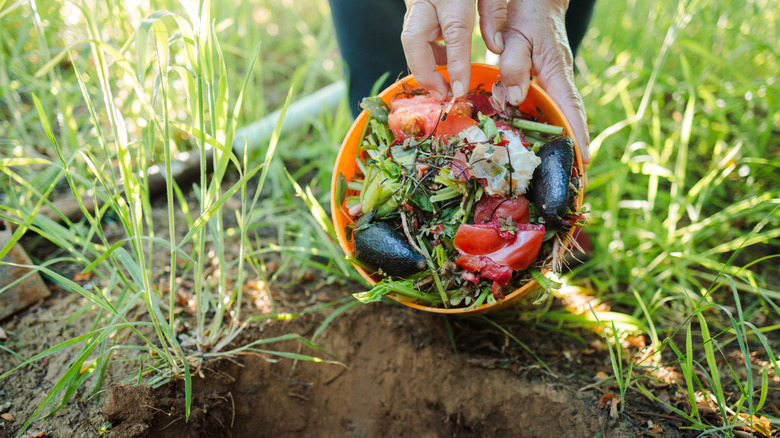 Woman pouring vegetables into a compost pit