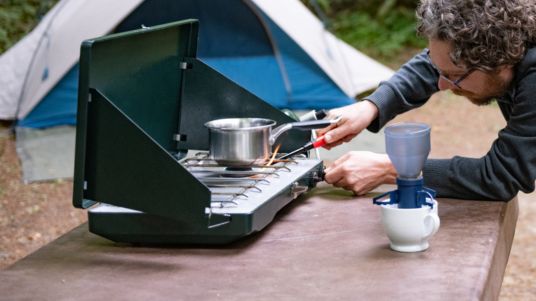 Man attempting to light camp stove