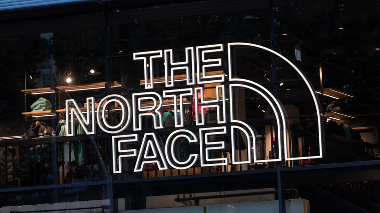 A storefront The North Face with sign on window 