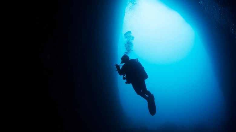 Deep water diver in a cave mouth