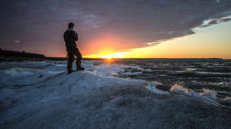 Person looking out over the water at sunset in Port Crescent State Park
