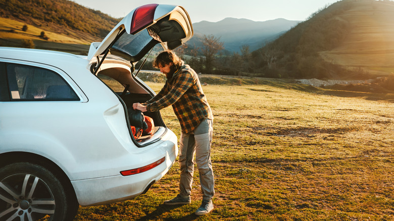 Man unpacking car to set up camp