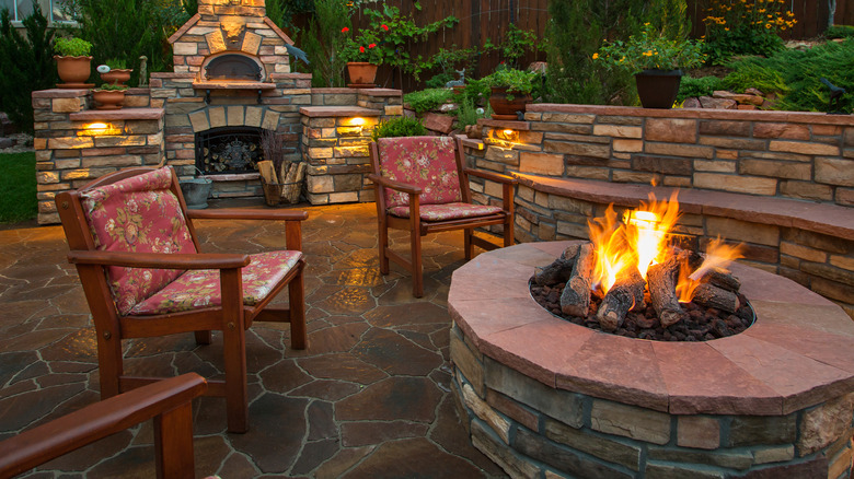 A garden at twilight with a lit fire pit