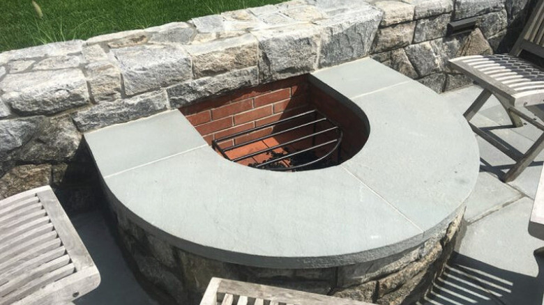 A half-circle fire pit with surrounding chairs