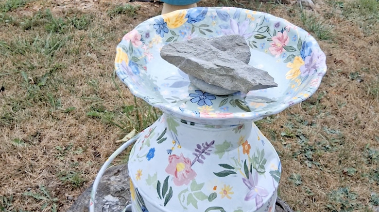 Painted milk can with a shallow birdbath on top