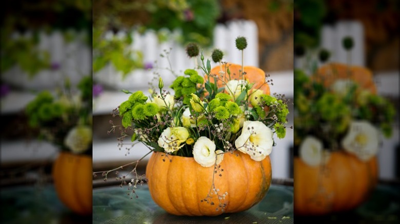 A pumpkin planter displaying pretty fall flowers