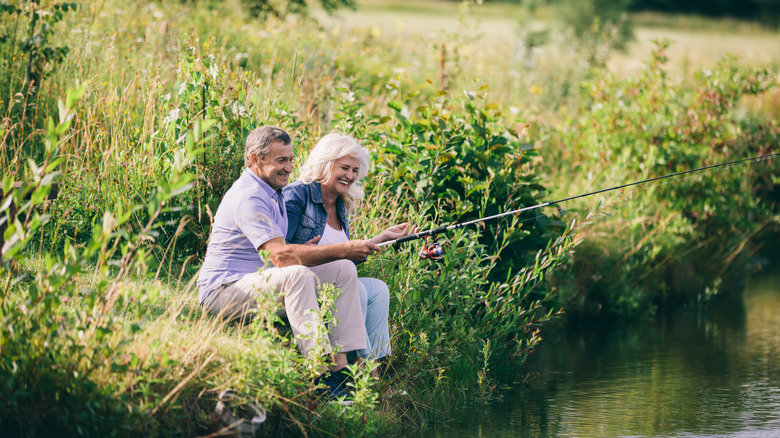 Senior couple fishing on the banks of a pond