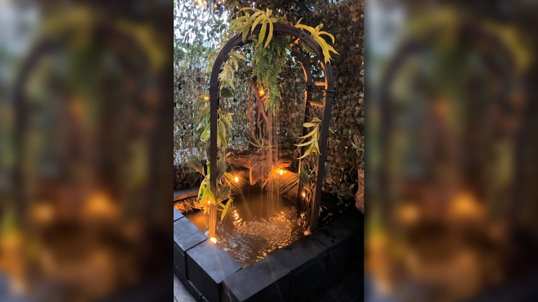 A short video showing a water feature including an arch and a small pond