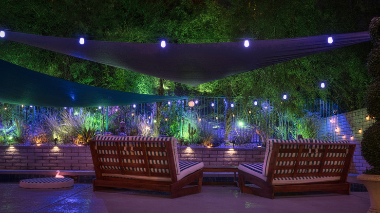Rear view of lounge chairs by pool at night
