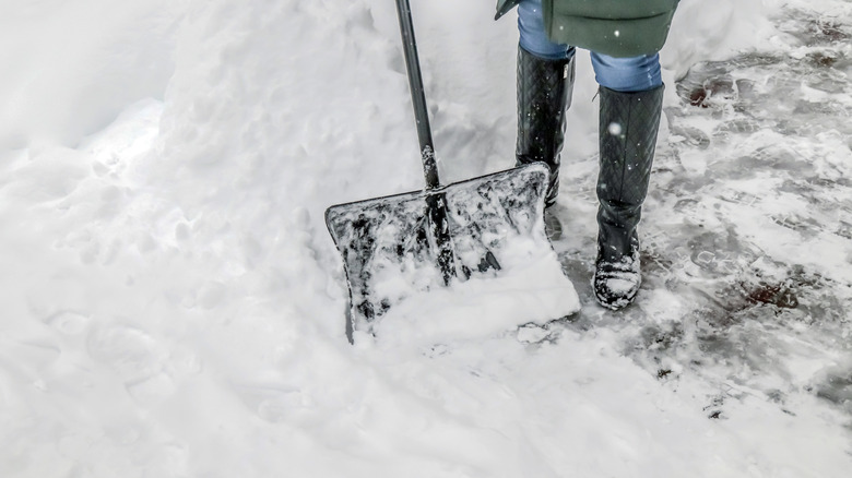 partial view of a person shoveling snow
