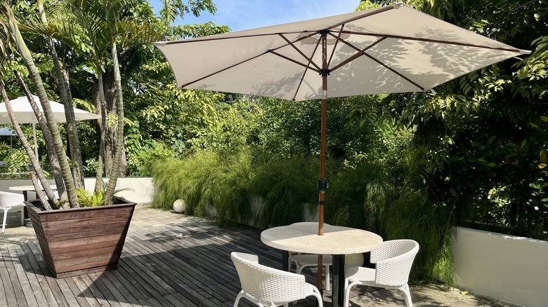 an outdoor patio table with a striped umbrella