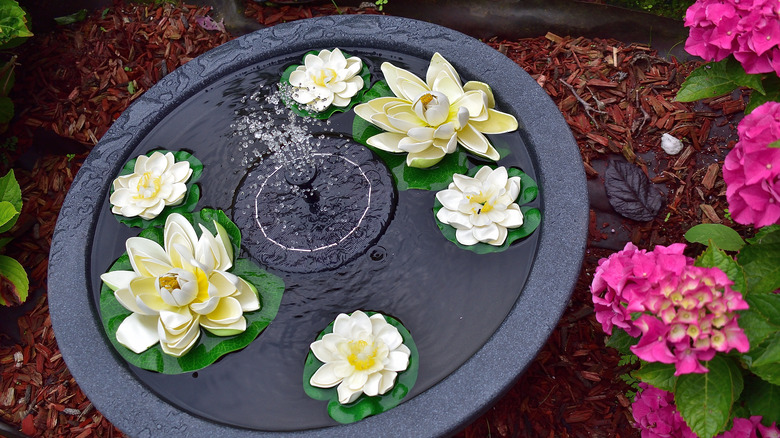 DIY fountain made from large pot, solar fountain, and floating flowers
