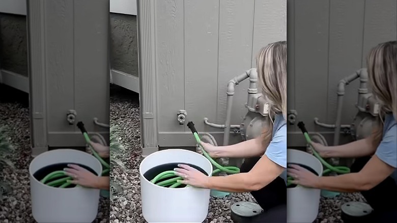 Garden hose coiled inside a large planter