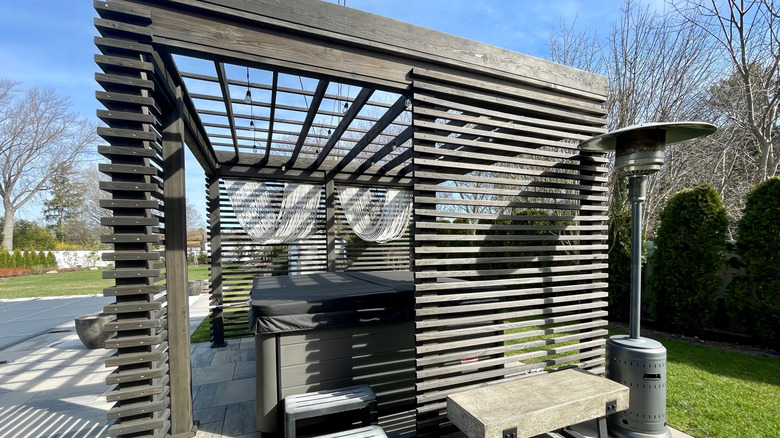 hot tub with pergola around it for privacy
