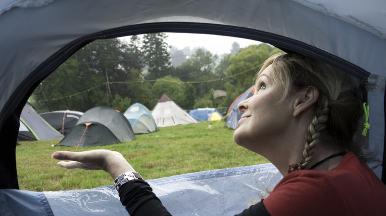woman in tent checking for rain
