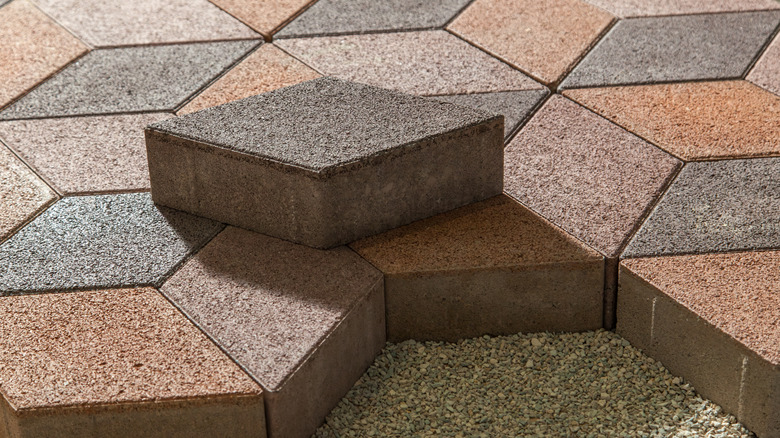 Interlocking rhombus-shaped patio pavers being laid down