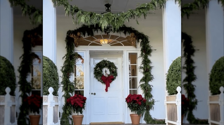 Front door with pine branch garland around it
