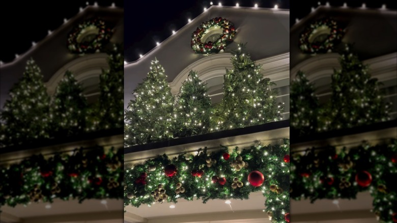 3 small Christmas trees on a porch roof