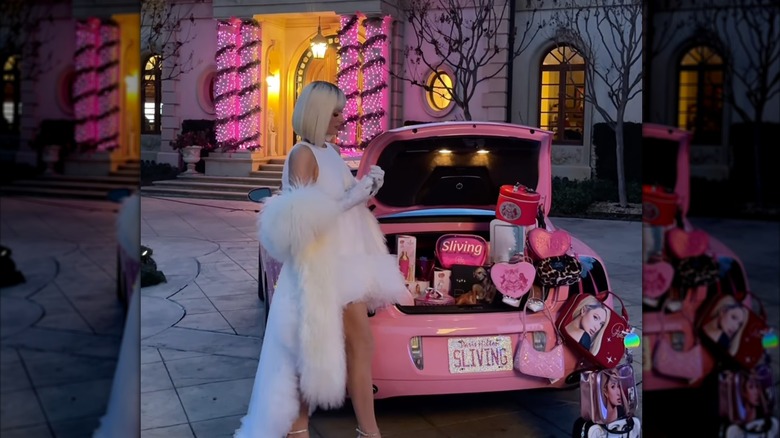 Paris Hilton posing near her front porch decorated with pink lights