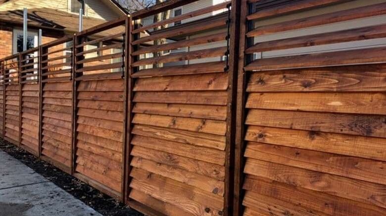 A wooden louver fence outside a suburban home
