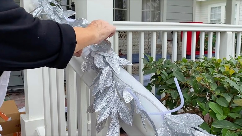 Person creating the pool noodle DIY for their porch