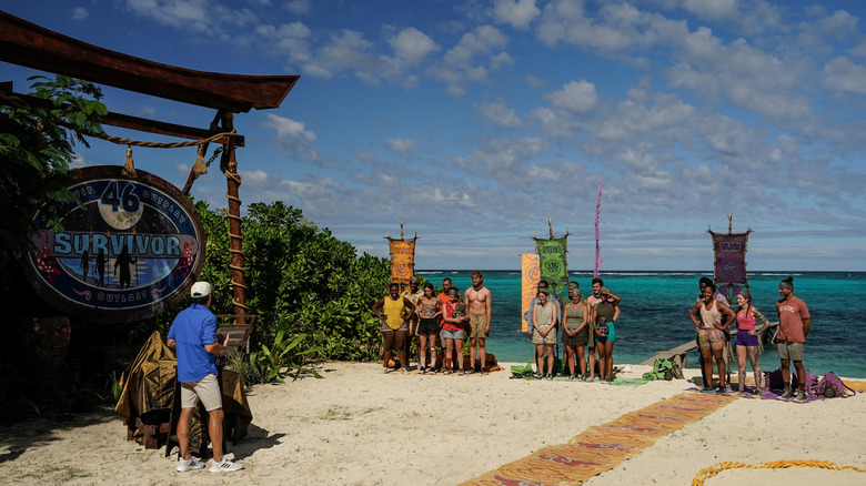 Survivor set with contestants on beach 