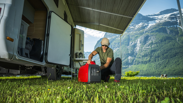 Man working on a portable generator while camping