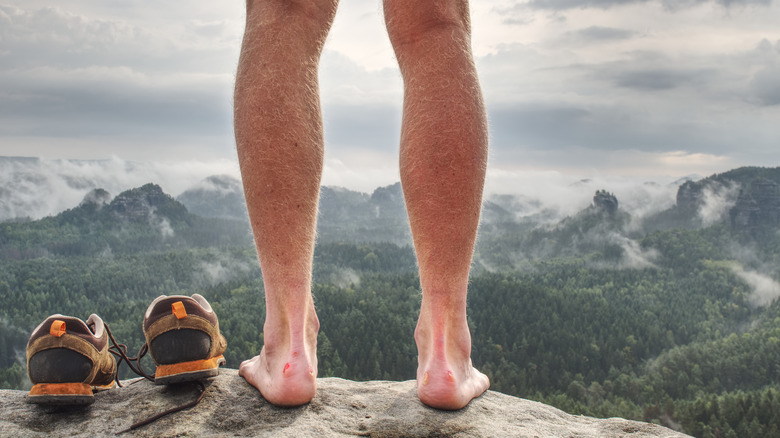 man's legs beside hiking boost in forest
