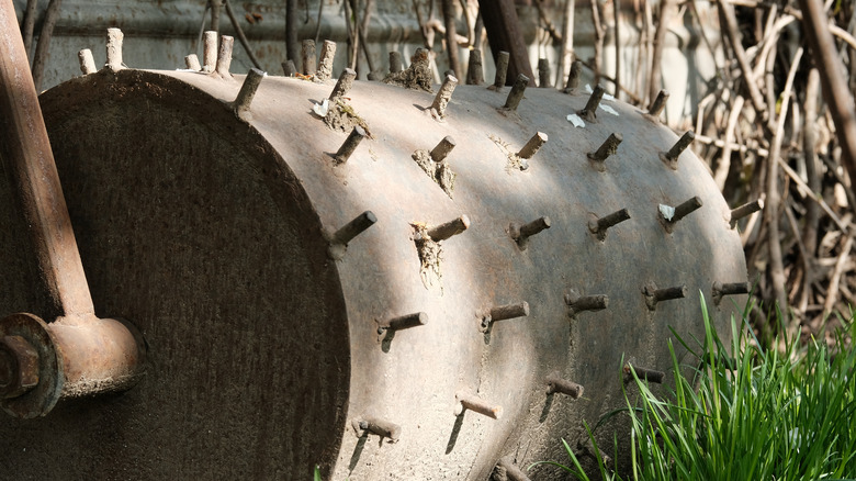 Old spike aerator leaning against fence