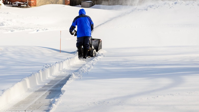 man clears a path with a snowblower