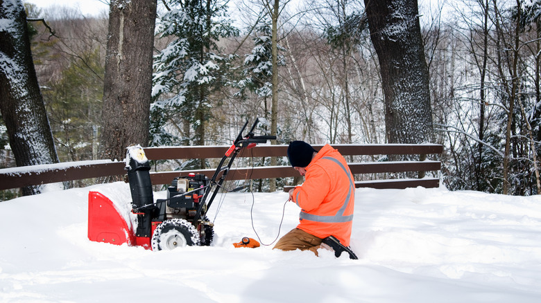 man working on a snowblower