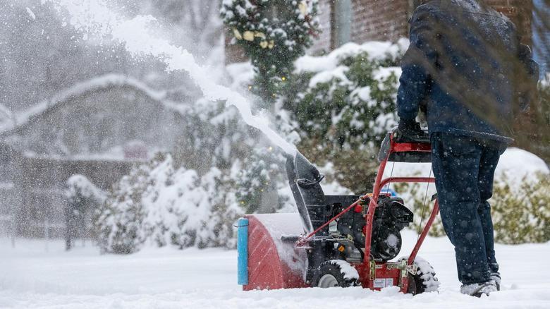 Using snow blower to clear sidewalk