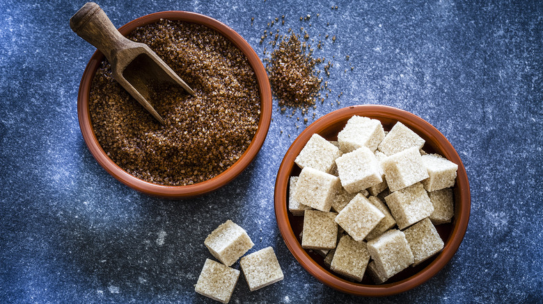 Bowls of sugar cubes and raw brown sugar