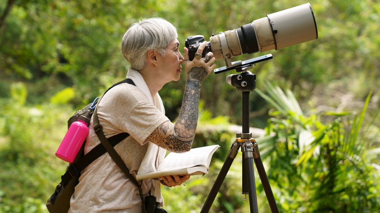 Birder with long lens camera on tripod
