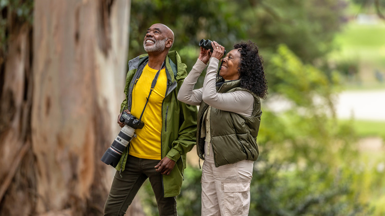 Couple birdwatching with camera and binoculars