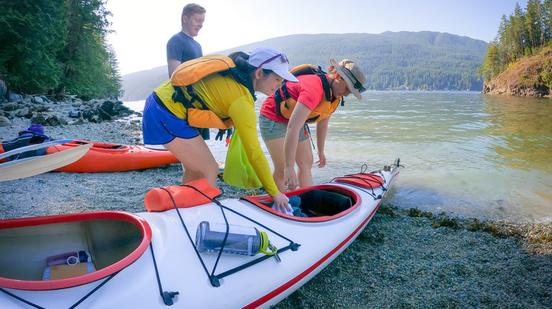 People loading gear into kayak