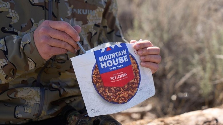 Hunter eating out of a Mountain House meal pouch