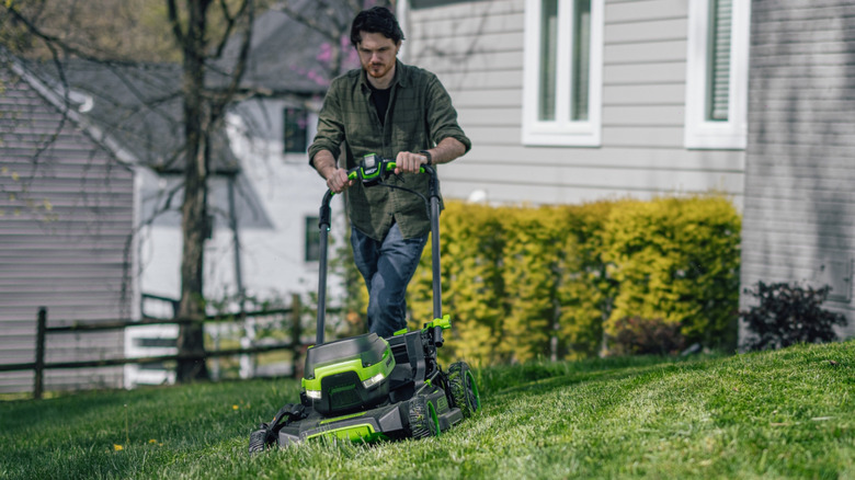 Man mowing lawn with a Greenworks push mower