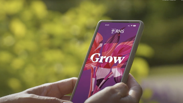 Hands holding a phone with the RHS Grow app on the screen