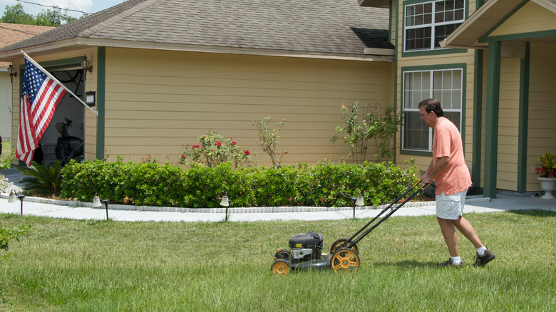 Man mowing lawn with push mower