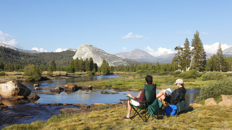 Campers sitting in camp chairs taking in a view