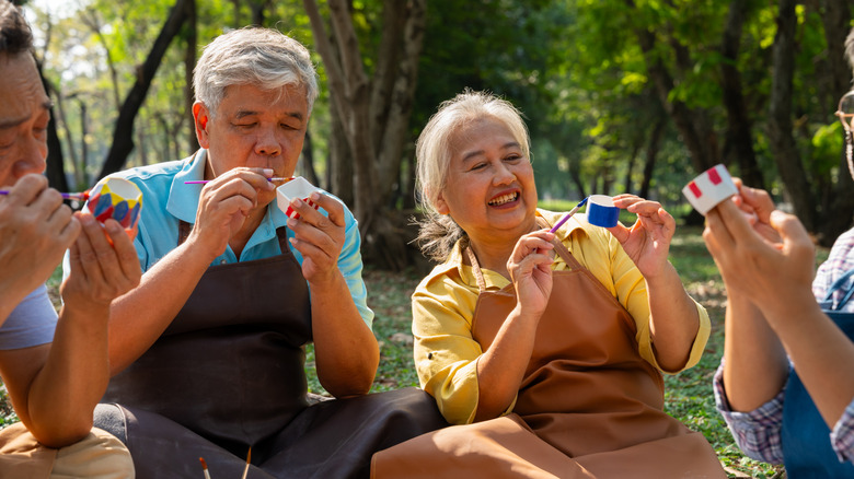 Older people crafting and painting outside