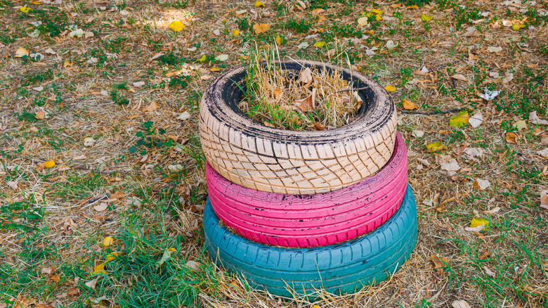 A stack of forgotten tire planters, painted in vibrant colors
