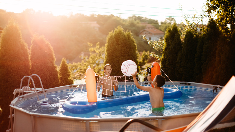 Kids playing in above ground pool as the sun shines