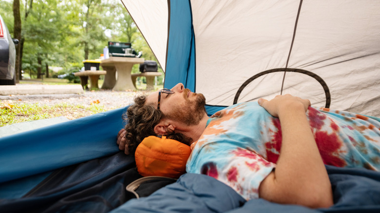 Person relaxing in tent in summer