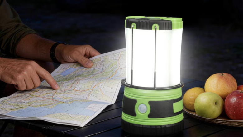 Person reading a map at night using a Lepro LEDO camping lantern