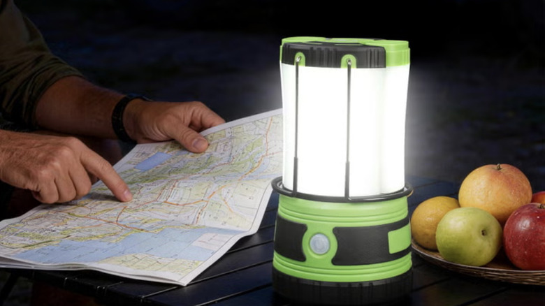Person reading a map at night using a Lepro LEDO camping lantern