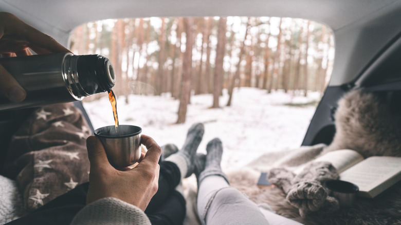 Couple in the back of their car winter camping