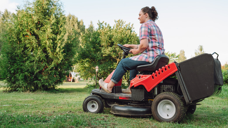 woman riding tractor mower