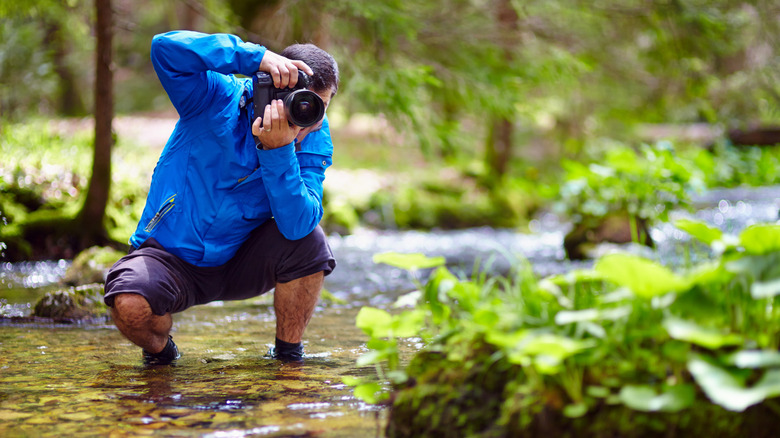 Man taking photograph in creek